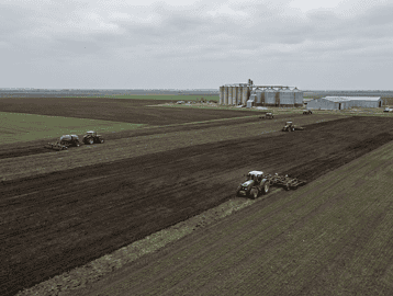 Aerial view of wheat and corn fields in Kazakhstan with agricultural machinery
